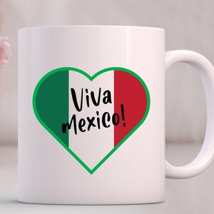 May include: White ceramic mug with a green, white, and red heart design. The heart has the text "Viva Mexico!" inside.