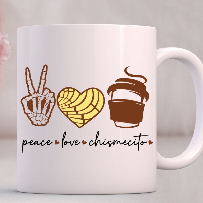 Op de afbeelding: Witte keramische koffiemok met een bruin vredesteken, een geel hart met een swirl-patroon en een bruine koffiebeker met stoom. De tekst "peace love chismecito" staat onder de afbeeldingen.