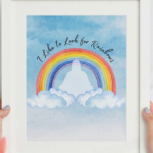 May include: A watercolor painting of a rainbow with the text "I like to look for rainbows" written in black cursive. The rainbow is in the sky with white clouds.