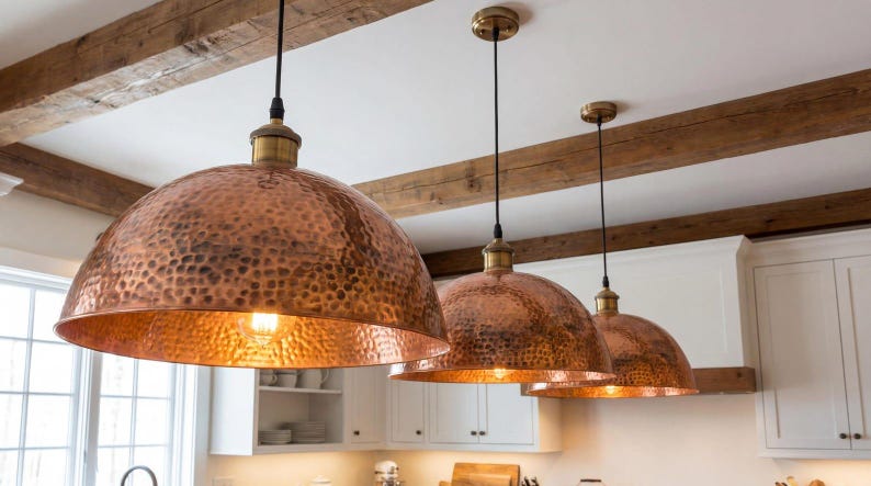 Hand-hammered copper pendant light with a large dome shape and warm reddish-orange metallic finish.