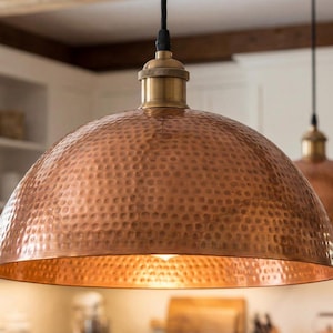 Close-up macro photo of the hammered indentations on a copper lamp shade showing handcrafted detail.
