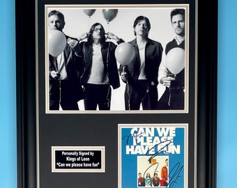 May include: A framed black and white photo of a band, Kings of Leon, with a signed album cover of their song "Can We Please Have Fun".