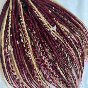 Colored dreadlocks. Braid extensions DE and SE. Synthetic dreadlocks in red tones.Wine colored hair.