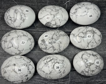 May include: Nine oval-shaped white stones with grey veining arranged in a grid. Each stone features a small circular white sticker with a black number printed on it, ranging from 36 to 44, identifying each individual piece in the collection.