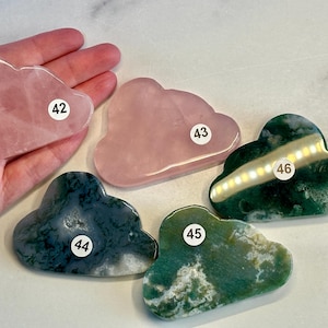 May include: Five cloud-shaped gua sha tools, two are pink and three are green with white swirls. The tools are numbered 42, 43, 44, 45, and 46.