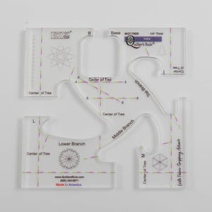 May include: Clear acrylic quilting templates with various shapes and markings for creating tree designs. Includes pieces labeled "Base", "Top Branch", "Middle Branch", and "Lower Branch". Features the text "Quilter's Rule" and "Made in America".