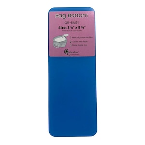 May include: A blue acrylic bag bottom with a pink label. The label reads "Bag Bottom" and includes instructions and measurements of 3.5" x 9.75". The product is made from clear acrylic.