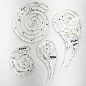 May include: Four clear acrylic quilting rulers in spiral and teardrop shapes. Each ruler has etched markings for measurements and design, with the text "Little Fabric Gripping Aids" and "Designed by Shari Wood".