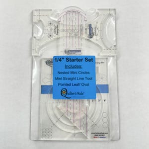 May include: A clear plastic quilting ruler set with a blue label that says "1/4" Starter Set" and includes "Nested Mini Circles, Mini Straight Line Tool, Pointed Leaf/Oval". The label also has the logo "Quilter's Rule".