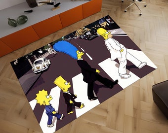 May include: A colorful rug featuring the Simpsons characters walking across a crosswalk, similar to the iconic Beatles album cover. The rug has a black background with white crosswalk lines and a city street scene in the background.