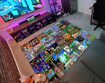 Puede incluir: Una alfombra grande con un diseño pixelado colorido que presenta varios personajes de videojuegos. La alfombra está colocada en un suelo de moqueta en una habitación con una configuración de juego, que incluye una pantalla de televisión grande, una silla de juego y una estantería con consolas de videojuegos.