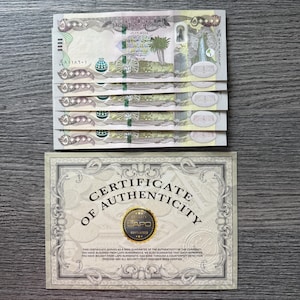 Puede incluir: Cinco billetes iraquíes de 50.000 dinares con texto en árabe, una palmera y una ilustración de una noria, acompañados de un certificado de autenticidad rectangular de Lapo Numismatics con un sello circular dorado y texto negro.