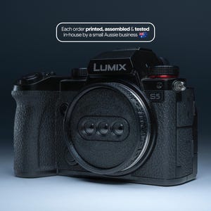 May include: A black Lumix S5 camera with a lens cap. The camera has the word "LUMIX" printed on the top. The text "Each order printed, assembled & tested in-house by a small Aussie business" is also visible.