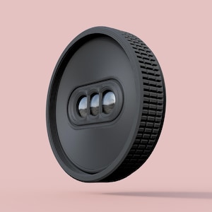 May include: A black, circular object with a textured edge and three small, reflective lenses. The object has a ridged design on the outer edge and a smooth, circular center. The background is a solid, light pink color.