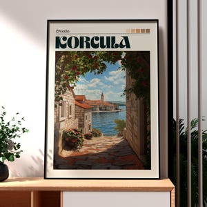 May include: A vintage travel poster featuring a scenic view of Korcula, Croatia. The poster has a black frame and features a colorful image of a narrow street lined with stone buildings, leading to a view of the water and a small island with a church.
