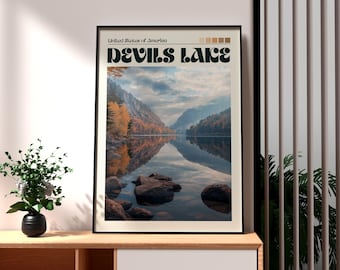 Pode incluir: Impressão artística emoldurada com uma vista panorâmica do Lago Devils nos Estados Unidos da América. A obra de arte mostra um lago sereno rodeado por montanhas e folhagem de outono, com o reflexo do lago espelhando a paisagem. O título "Devils Lake" é exibido em negrito e com uma fonte estilizada.