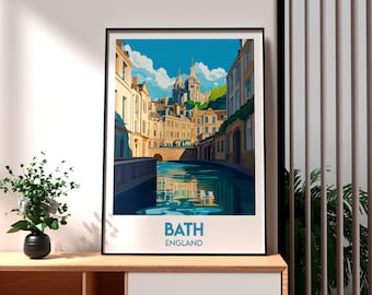 May include: A framed art print featuring a stylized illustration of Bath, England. The artwork depicts a canal with buildings on either side, a bridge, and a cathedral in the background. The text "BATH ENGLAND" is at the bottom.