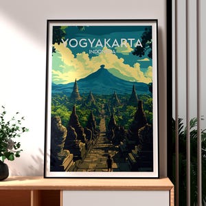 May include: A vintage travel poster featuring a colourful illustration of a mountain range and a pathway leading to a temple complex in Yogyakarta, Indonesia. The poster has the text "Yogyakarta, Indonesia" at the top.