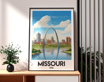 Puede incluir: Un póster enmarcado que representa el Gateway Arch en St. Louis, Missouri, con un paisaje urbano y un río. El cielo azul está salpicado de nubes. El texto "MISSOURI USA" está en la parte inferior. El póster está sobre una superficie de madera.