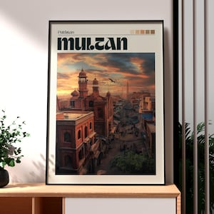 May include: Framed art print featuring a vibrant cityscape of Multan, Pakistan, under a dramatic sunset sky. The print includes the city's name in bold, stylized text. The buildings are a reddish-brown color.