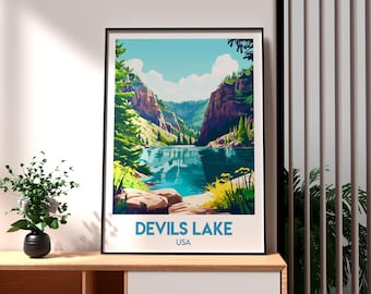 May include: A framed art print of Devils Lake, USA. The landscape art features a serene lake surrounded by cliffs and lush greenery under a blue sky with fluffy clouds. The print is displayed on a wooden surface.