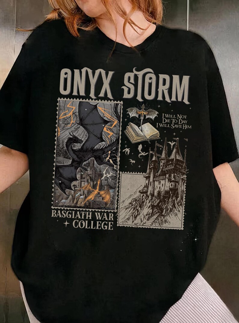 May include: Black t-shirt with a graphic print of a dragon, a castle, and a book. The text "ONYX STORM", "I WILL NOT DIE TO DAY I WILL SAVE HIM", and "BASGIATH WAR + COLLEGE" is printed on the shirt.