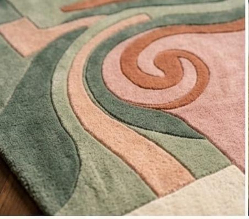 May include: Close-up of a colorful rug with an abstract design. The rug features a mix of colors, including green, peach, and brown, arranged in flowing, curved patterns. The texture appears soft and plush, suggesting a comfortable floor covering.