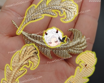 May include: Four gold-coloured metal feather-shaped brooches. The brooches are arranged in a hand, with one brooch in the centre and the other three surrounding it. The brooch in the centre has a small cartoon image of a character with white hair and red horns.
