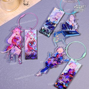 Puede incluir: Cinco llaveros holográficos con personajes de anime del videojuego Genshin Impact. Los llaveros están en varias poses y presentan a los personajes Shenhe, Yae Miko, Kazuha y otros dos. Los llaveros están hechos de acrílico transparente y tienen un acabado iridiscente arcoíris.