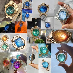 May include: A selection of gold-toned pendants, each with a coloured glass orb. The orbs display detailed designs in blue, green, orange, and purple. Some pendants have the text "PlayerGoGoGo.com".
