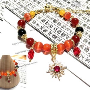 May include: A red, orange and black beaded bracelet with a gold star charm. The bracelet is on a white background with Chinese characters.