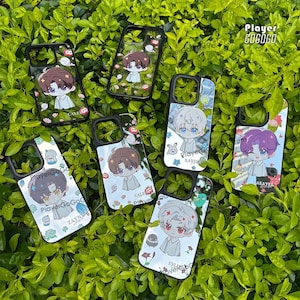 Könnte beinhalten: Eine Sammlung von Handyhüllen mit schwarzen Rahmen und verschiedenen Anime-Charakterdesigns. Jede Hülle zeigt einen anderen Charakter mit einzigartigen Haarfarben und Outfits, vor einem weißen Hintergrund mit floralen und dekorativen Elementen. Die Hüllen werden auf einem Bett aus grünem Laub präsentiert.