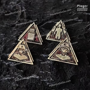 Könnte beinhalten: Vier goldfarbene, dreieckige Anstecknadeln mit verschiedenen geätzten Designs. Eine Nadel zeigt einen USB-Stick, eine andere Figuren und die anderen eine Person mit Helm. Die Nadeln haben einen roten Rand und sind auf einem dunklen, strukturierten Hintergrund platziert.
