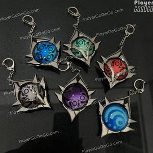 K&ouml;nnte beinhalten: F&uuml;nf silberne Schl&uuml;sselanh&auml;nger mit verschiedenen farbigen Designs. Jeder Schl&uuml;sselanh&auml;nger hat einen silbernen Metallrahmen mit einem kreisf&ouml;rmigen Design in der Mitte. Die Designs sind blau, gr&uuml;n, rot, lila und blau. Die Schl&uuml;sselanh&auml;nger sind in einem Kreis auf einer schwarzen Oberfl&auml;che angeordnet.
