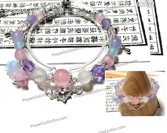 May include: A delicate bracelet featuring a clear, circular design adorned with a variety of pastel-colored beads. The bracelet includes pink, purple, and white beads, with a silver-colored charm and chain. The background includes Chinese characters.