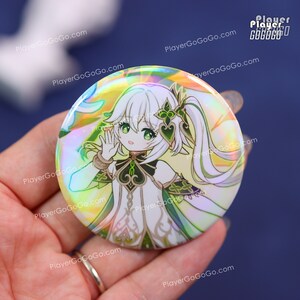 Puede incluir: Un bot&oacute;n redondo con un personaje de estilo anime con cabello blanco y ojos verdes. El personaje lleva un atuendo blanco y verde. El bot&oacute;n tiene un acabado hologr&aacute;fico iridiscente. El logotipo de PlayerGoGoGo.com es visible.