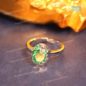 May include: A silver ring with a large green gemstone set in a decorative silver setting.