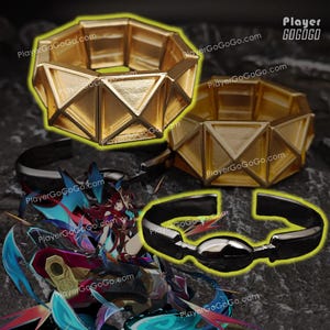Op de afbeelding: Twee gouden armbanden met een geometrisch ontwerp. De armbanden zijn gemaakt van metaal en hebben een glanzende afwerking. De armbanden liggen op een donkere achtergrond. PlayerGoGo.com is gedrukt op de achtergrond.
