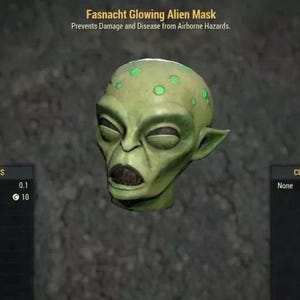 Op de afbeelding: Een groen alienmasker met gloeiende groene ogen en vlekken. Het masker is gelabeld met "Fasnacht Glowing Alien Mask" en "Prevents Damage and Disease from Airborne Hazards".