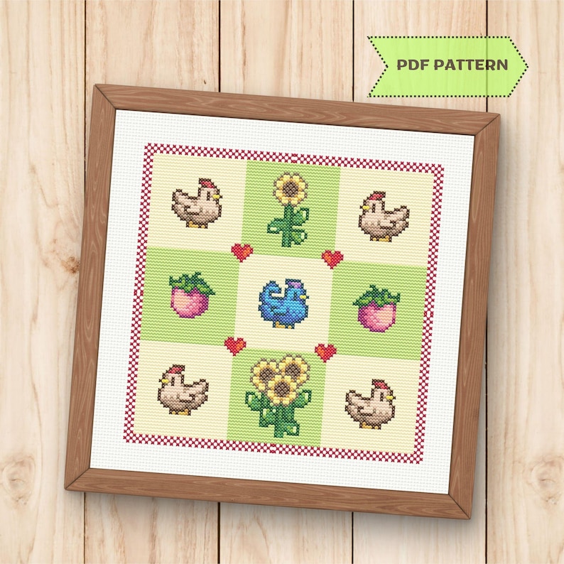 Op de afbeelding: Kruissteekpatroon ingelijst in een houten frame. Het ontwerp toont kippen, zonnebloemen, harten en potplanten in een rasterpatroon. De tekst "PDF PATTERN" staat in een groene banner rechtsboven.