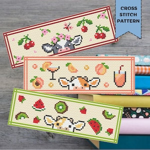 May include: Three cross-stitch patterns featuring cow faces with fruit and drink designs. The top pattern has cherries and flowers, the middle has peaches and a cocktail, and the bottom has watermelon and kiwi. The text "CROSS STITCH PATTERN" is in a blue banner.