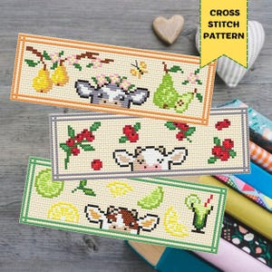 Puede incluir: Tres marcapáginas de punto de cruz con diseños de vaca y motivos de frutas o bebidas. El marcapáginas superior presenta peras y flores, el del medio bayas y el inferior limones, limas y un cóctel. El texto "CROSS STITCH PATTERN" está en la parte superior derecha.