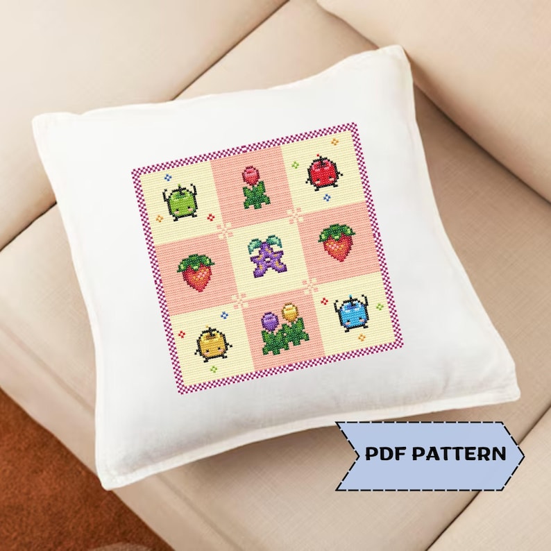 Puede incluir: Coj&iacute;n cuadrado blanco con un dise&ntilde;o de punto de cruz con frutas y verduras pixeladas de colores. El dise&ntilde;o incluye fresas, manzanas y otros productos en un patr&oacute;n de cuadr&iacute;cula. El texto "PDF PATTERN" est&aacute; en una flecha azul.