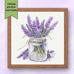 May include: A cross stitch pattern featuring a glass jar filled with lavender flowers. The jar is tied with twine and the flowers are a light purple colour.
