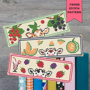 Puede incluir: Tres marcapáginas con patrones de punto de cruz con diseños de frutas y vacas. El marcapáginas superior presenta bayas rojas y uvas. El marcapáginas central tiene melón y una calabaza. El marcapáginas inferior tiene un batido, frambuesas y moras. El texto "CROSS STITCH PATTERN" está en la parte superior derecha.