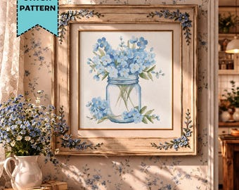 May include: A framed cross-stitch pattern featuring a bouquet of blue flowers in a mason jar. The artwork is in a wooden frame with floral accents. The text "CROSS STITCH PATTERN" is in a teal banner in the upper left corner.