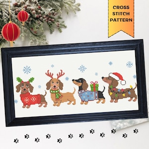 May include: A framed cross-stitch pattern featuring four dachshunds in festive attire. One dog wears a red sweater, another has antlers and a scarf, a third has a blue sweater and gifts, and the last wears a Santa hat and lights. The text "CROSS STITCH PATTERN" is in the upper right.