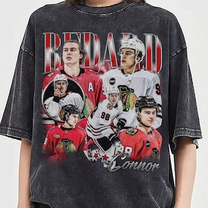 May include: Dark gray t-shirt featuring a collage of hockey players in red and white jerseys. The design includes the name "BEDARD" in large, red, vertical letters and the name "Connor" in a script font.