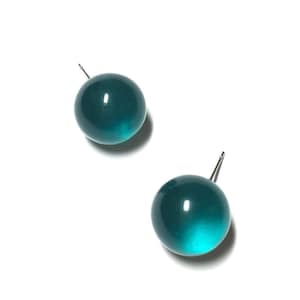 May include: A pair of teal blue round stud earrings. The earrings are made of a smooth, shiny material.