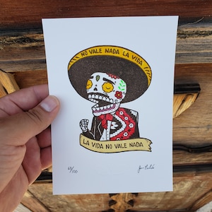 May include: A black and white illustration of a skeleton wearing a sombrero and a suit. The skeleton is singing and the text "NO VALE NADA LA VIDA" is written above the skeleton. The text "LA VIDA NO VALE NADA" is written on a banner below the skeleton. The image is numbered 68/100.